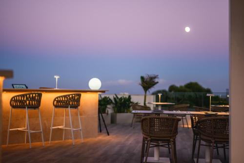a patio with chairs and a bar with a view at XVI Suites - Adults Only in Naxxar