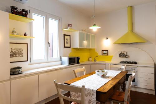 a kitchen with a wooden table and a yellow at Dimora storica, appartamento in Villa Pampinuccia in Bassano del Grappa