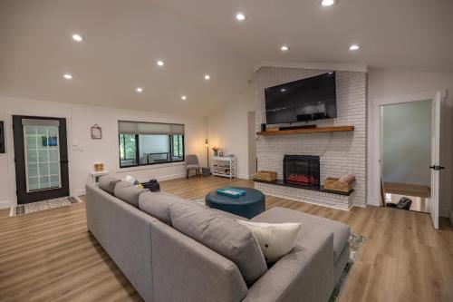 a living room with a couch and a fireplace at Mid-century Modern Impeccable Remodel with Hot Tub in Asheville