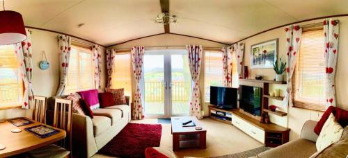 a living room with a couch and a tv at Warren Haven in Dawlish Warren