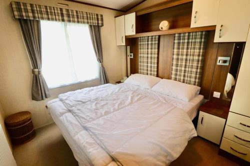 a large bed in a room with a window at Warren Haven in Dawlish Warren