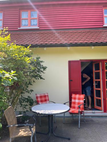a man standing inside of a red house at Möwenblick Bakenberg-41 Ferienwohnung mit Terrasse, Doppelbett, Schlafsofa, vollständige Komfortküche in Dranske