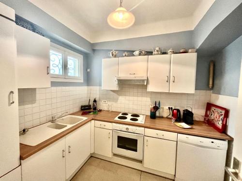 une cuisine avec des armoires blanches et un évier dans l'établissement 45 Clemenceau by Welcome to Cannes, à Cannes