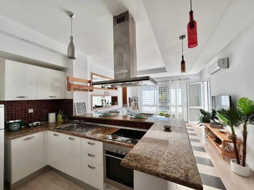 a kitchen with white cabinets and granite counter tops at Sunny Blue in Sidi Daoud