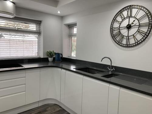 a kitchen with a large clock on the wall at Wayside farmhouse stay 