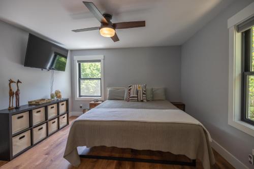 um quarto com uma cama e uma ventoinha de tecto em Mid-century Modern Impeccable Remodel with Hot Tub em Asheville