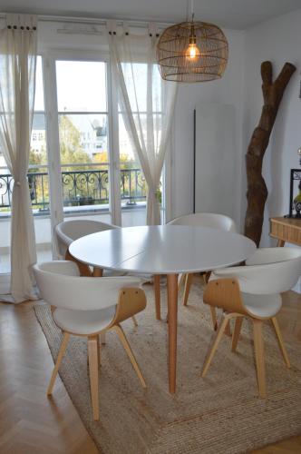 a dining room with a white table and chairs at Cosy nest 6km from Paris in Le Plessis-Robinson