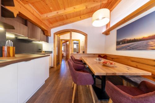 a kitchen and dining room with a wooden table and chairs at Haus Wildkarblick in Krimml
