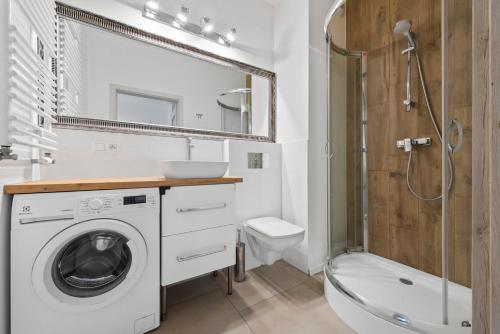 een badkamer met een wasmachine en een douche bij Comfy studio. City center. in Warschau