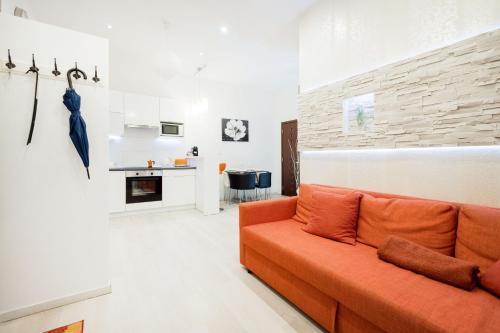 un salon avec un canapé orange et une cuisine dans l'établissement Modern Westend CityCenter Home, à Budapest