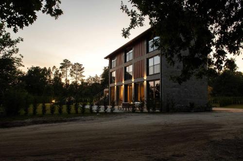 a large house with a sunset in the background at Ermo Loft - Casas do Ermo in Fafe