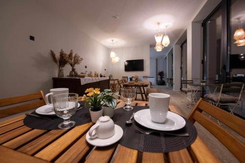a wooden table with plates and glasses on top of it at Ermo Loft - Casas do Ermo in Fafe