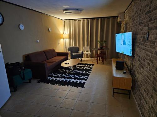 a living room with a couch and a flat screen tv at Happy Home in Eilat
