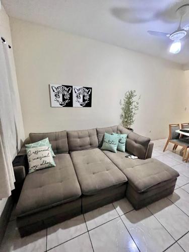 a living room with a brown couch with pillows at Andres' Home Vila Bretas in Governador Valadares