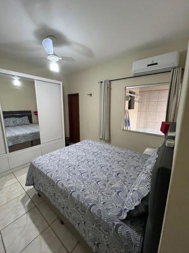 - une chambre avec un lit et un grand miroir dans l'établissement Andres' Home Vila Bretas, à Governador Valadares