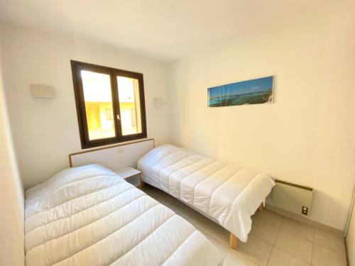 une chambre avec deux lits et une fenêtre dans l'établissement Appartement 8 Terra Bella 1 Porticcio, à Porticcio