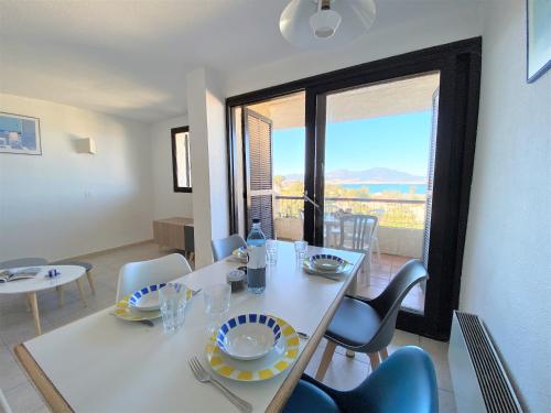 une salle à manger avec une table et des chaises et une fenêtre dans l'établissement Appartement 8 Terra Bella 1 Porticcio, à Porticcio