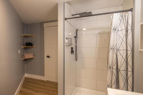 uma casa de banho com um chuveiro e uma porta de vidro em Mid-century Modern Impeccable Remodel with Hot Tub em Asheville