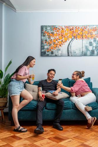 a group of people sitting on a couch at Tagle Casa del Lado Santiago Providencia in Santiago