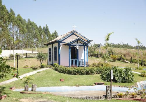 a small blue and white house in a garden at Vale Encantado - Eco Park & Hotel in Biritiba-Mirim