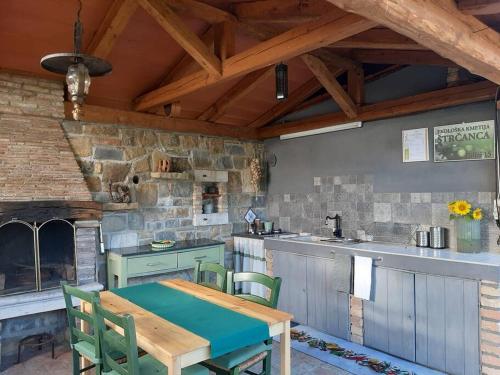 an outdoor kitchen with a table and a stone wall at House in Istria in pristine nature in Šmarje