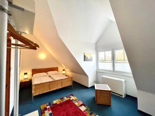 ティンメンドルフにあるFerienwohnung Haus 2のベッドと窓が備わる屋根裏部屋