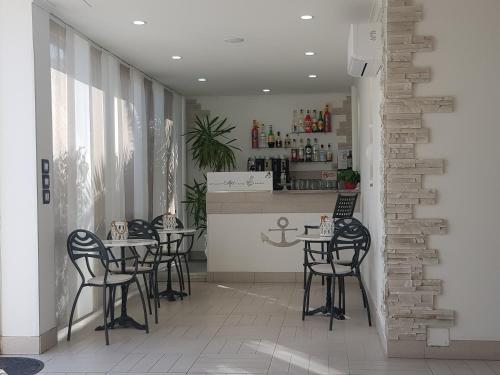 - un restaurant avec des tables et des chaises noires dans une salle dans l'établissement MILANO, à Marina di Pietrasanta