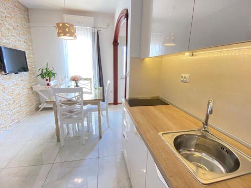 a kitchen with a sink and a table in it at HAPPY DAYS in Trogir