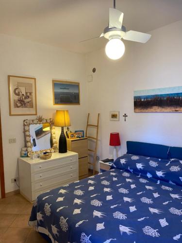 ein Schlafzimmer mit einem blauen Bett, einer Kommode und einer Decke in der Unterkunft Sunny house in Porto Santo Stefano