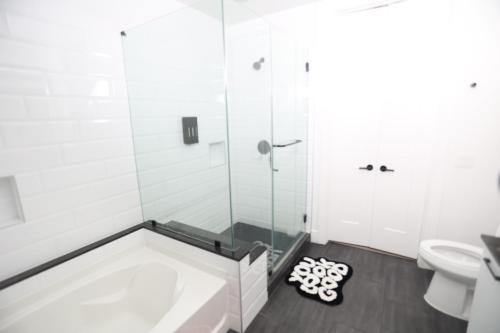 a bathroom with a shower and a toilet at Skyline Retreat Downtown HTX in Houston