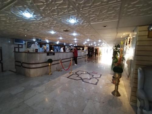 a lobby with a bar with a person standing at a counter at اجنحة روتانة الفرسان بالحمرا in Jeddah