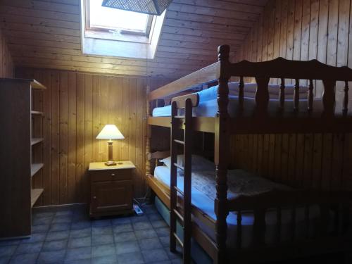 ル・ティヨにあるLocation chaletsのキャビン内の二段ベッド2台が備わる客室です。