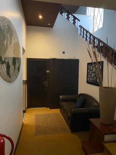 a living room with a leather couch and a door at HOTEL RESIDENCIAL CITY in Maputo