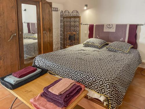 une chambre avec un lit et un miroir dans l'établissement Le Petit Mas Rey, à Eyragues