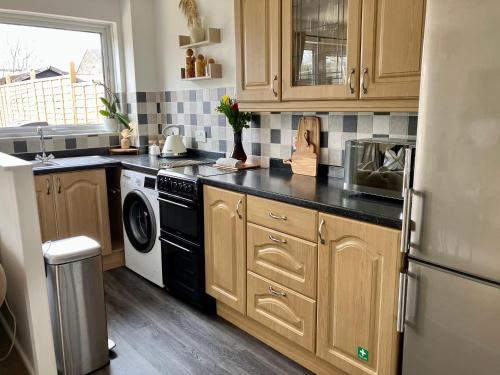 cocina con nevera y lavavajillas en Central, Cosy Home with Large Garden & Parking, Bournemouth en Bournemouth