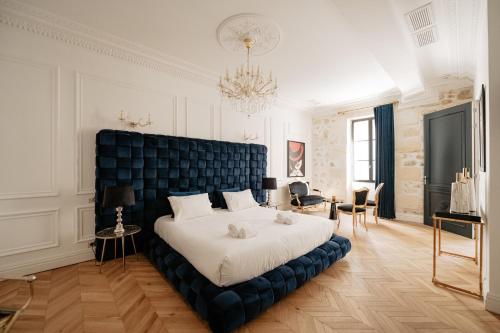 une chambre avec un grand lit avec une tête de lit bleue dans l'établissement Château Grand-Arnaud, à Vignac