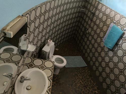 a small bathroom with a toilet and a sink at Lodge des marseillais in Ouoran
