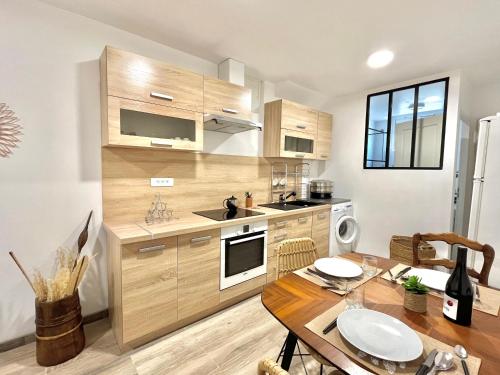 une cuisine avec des armoires en bois et une table en bois dans l'établissement Appartement rez de villa CORTE, à Corte