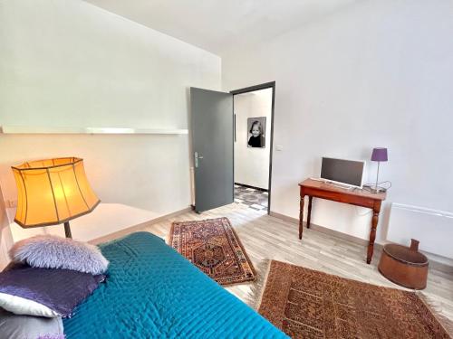 une chambre avec un lit, une table et un miroir dans l'établissement Appartement rez de villa CORTE, à Corte