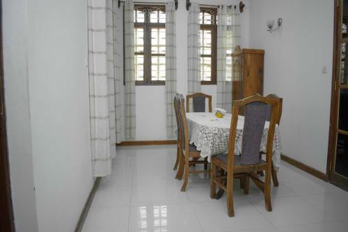 a dining room with a table and chairs at SULKHAN SERVICED APARTMENT in Chukwani