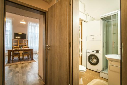 a bathroom with a toilet and a dining room at Entire Flat in Kecskemét Center in Kecskemét