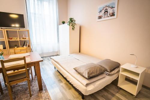 a small bedroom with a bed and a desk at Entire Flat in Kecskemét Center in Kecskemét