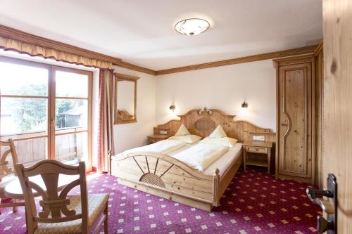 um quarto com uma cama, uma secretária e uma janela em Pension Schmidinger em Kitzbühel
