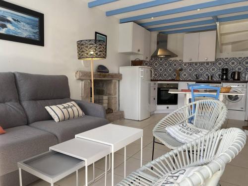 un salon avec un canapé et des chaises et une cuisine dans l'établissement 665 - Maison en pierre sur les hauteurs de Tu Es Roc, à Erquy, à Erquy