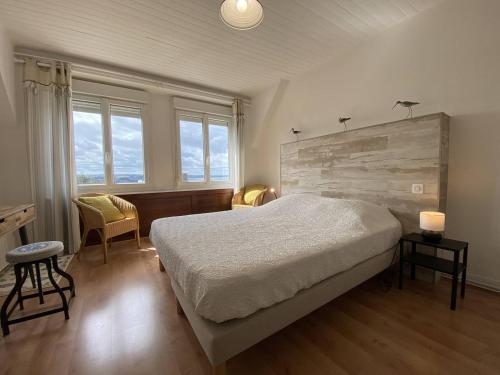 une chambre avec un lit, un bureau et des fenêtres dans l'établissement 665 - Maison en pierre sur les hauteurs de Tu Es Roc, à Erquy, à Erquy