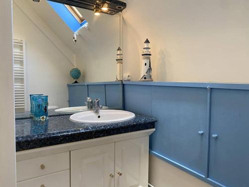La salle de bains est pourvue d'un lavabo, d'un miroir et d'un phare. dans l'établissement 665 - Maison en pierre sur les hauteurs de Tu Es Roc, à Erquy, à Erquy