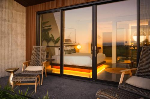 a bedroom with a bed and two chairs on a balcony at ViewPoint Hotel in York