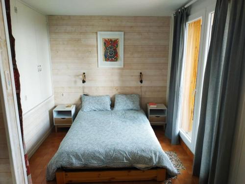 Ce lit se trouve dans un dortoir doté de 2 tables et d'une fenêtre. dans l'établissement Appartement confort lumineux, terrasse avec vue, à Font-Romeu-Odeillo-Via