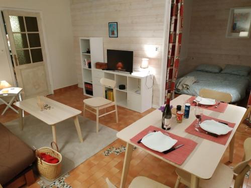 un salon avec une table et un lit dans l'établissement Appartement confort lumineux, terrasse avec vue, à Font-Romeu-Odeillo-Via