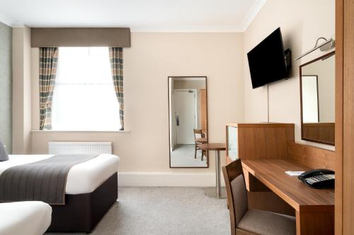 a hotel room with a bed and a desk at Royal Station Hotel- Part of the Cairn Collection in Newcastle upon Tyne